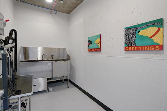 A room with a table and two paintings on the wall.