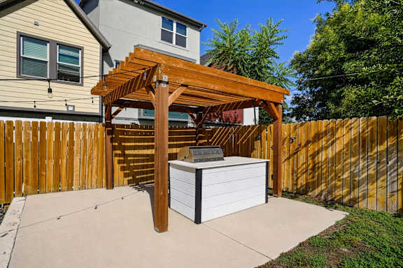 A wooden pergola is attached to a white box.