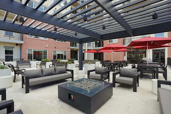 A patio with a fire pit and seating area.