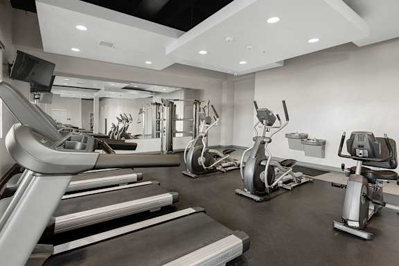 A spacious gym with treadmills, elliptical machines, and other exercise equipment.