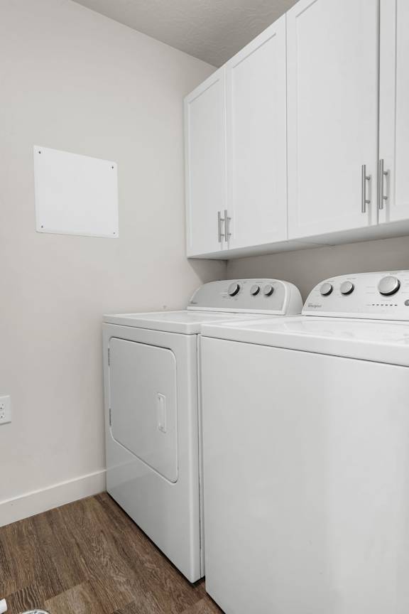 A white washing machine and dryer in a laundry room.