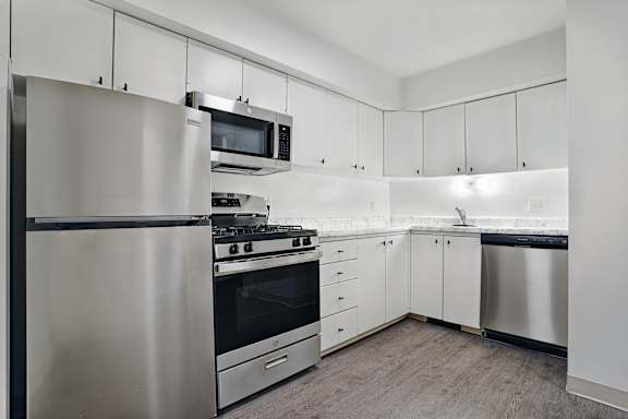 A modern kitchen with stainless steel appliances and white cabinets.