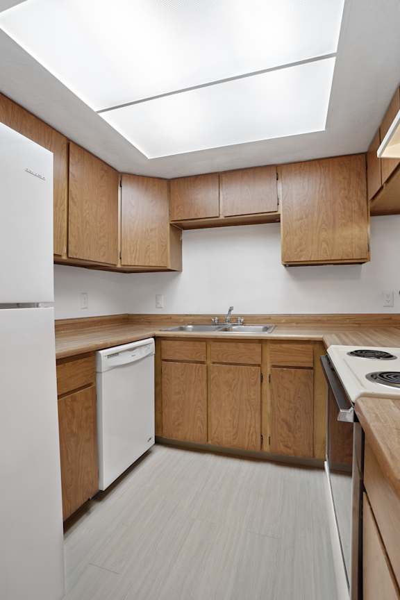 A kitchen with wooden cabinets and a white refrigerator.