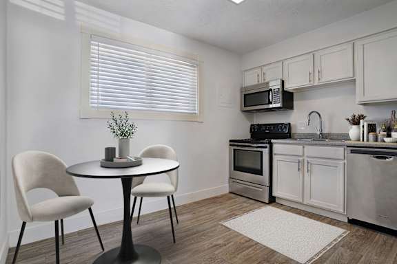 A kitchen with a table and chairs.