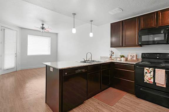 A kitchen with dark wood cabinets and a black oven.