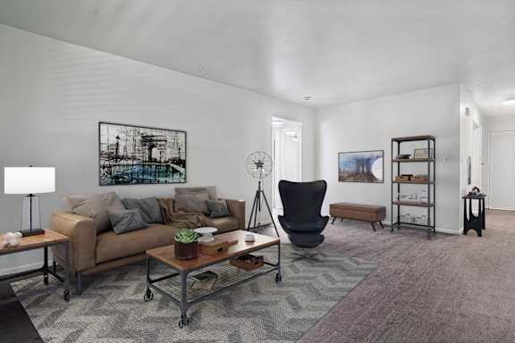 A modern living room with a white sofa, a black coffee table, and a TV.