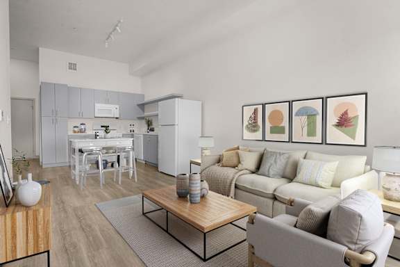 A living room with a grey couch, a coffee table, and a dining table with chairs.