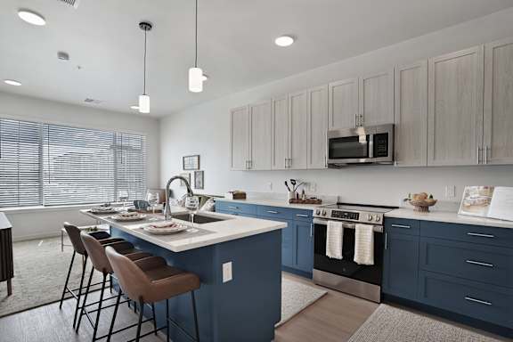 A kitchen with a blue island and wooden cabinets.