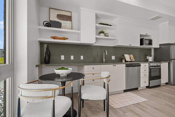 A modern kitchen with a table and chairs.