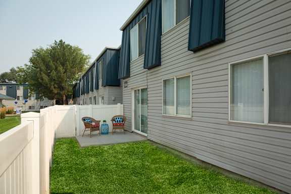 A row of houses with a white picket fence in front.