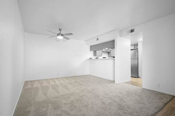 A room with a ceiling fan and a carpeted floor.