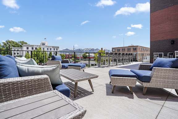 A patio with wicker furniture and a table.