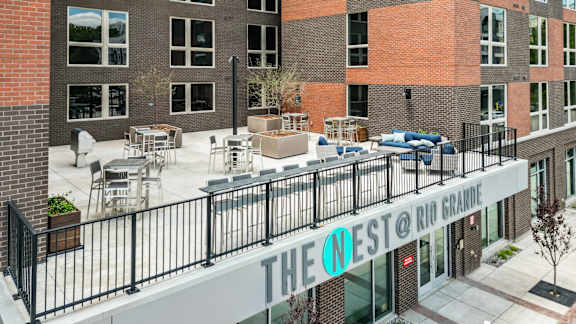 The Nest @ Rio Grande is a modern building with a balcony and outdoor seating area.