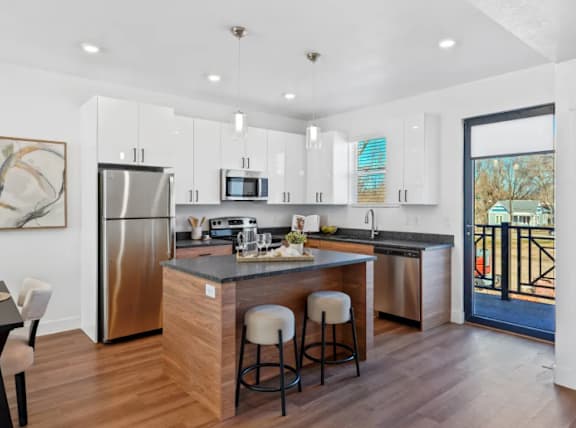 A modern kitchen with a large island and stainless steel appliances.
