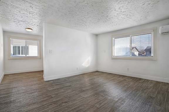 A room with a window and a wooden floor.