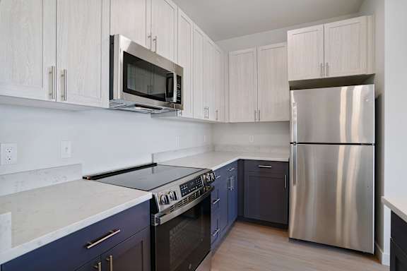 A kitchen with a stove top oven and a refrigerator.