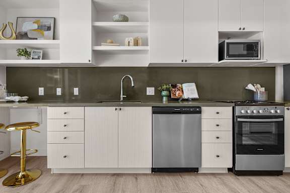 A modern kitchen with white cabinets and a black dishwasher.