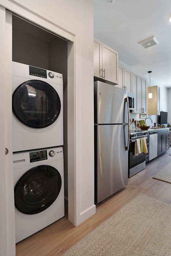 A modern kitchen with a washer and dryer built into the cabinetry.