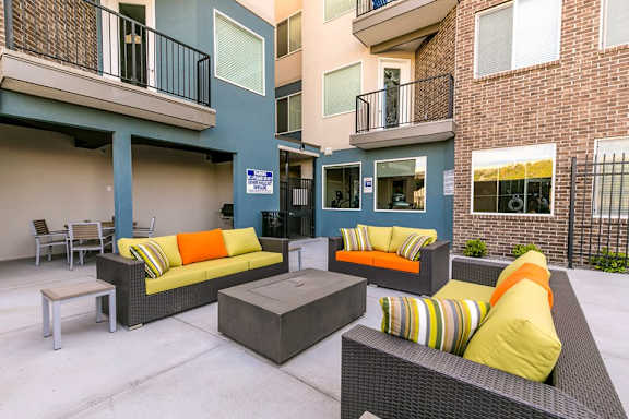 A patio with a couch, chairs, and a table.