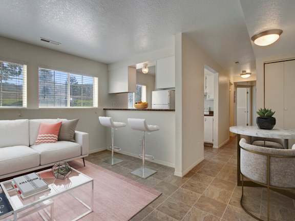 A living room with a white couch and a glass coffee table.