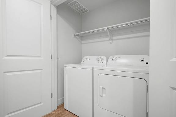 A white laundry room with a washer and dryer.