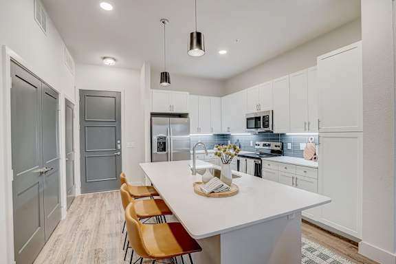 a kitchen with white cabinets and a white counter top at The Mill Old Town, Lewisville