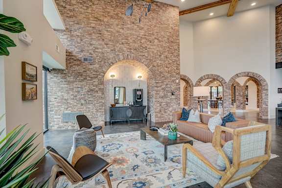 a living room with furniture and a brick wall at The Mill Old Town, Lewisville, TX