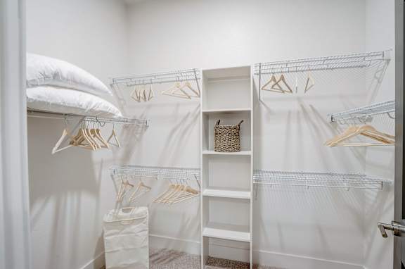 a closet with white curtains and white shelves and a bed with white pillows at The Mill Old Town, Lewisville, 75057