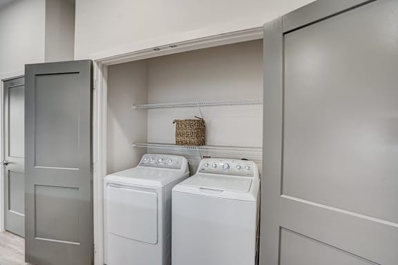 a washer and dryer in a laundry room with a door to the closet at The Mill Old Town, Lewisville Texas