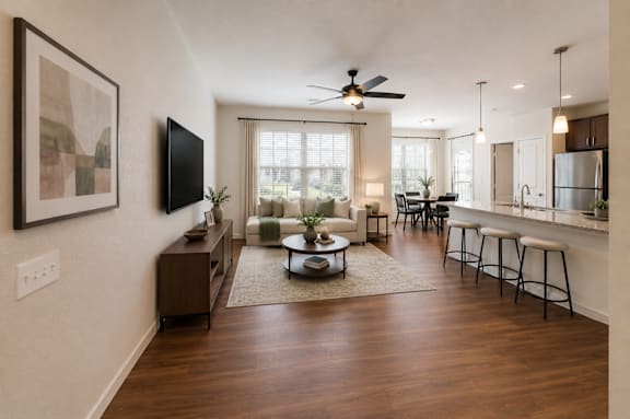 A living room with a brown rug and a wooden floor.