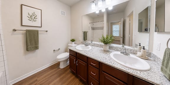 Spacious bathroom with a double vanity, large mirror, and modern finishes in a two-bedroom apartment at Auberge of Tyler.