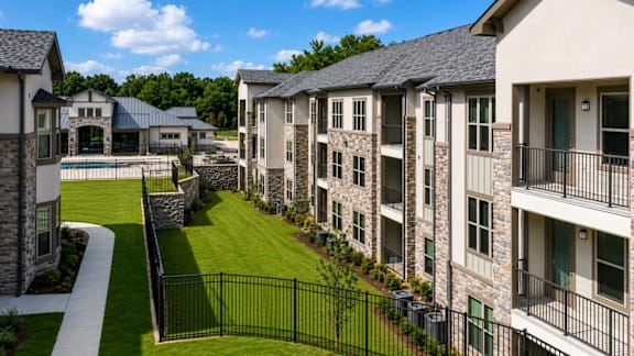 Auberge of Tyler apartment buildings overlooking landscaped lawns and mature trees.