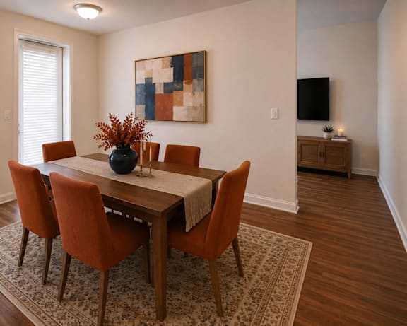 A dining room with a table and chairs.