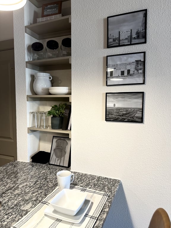 a corner of a kitchen with a counter and pictures on the wall