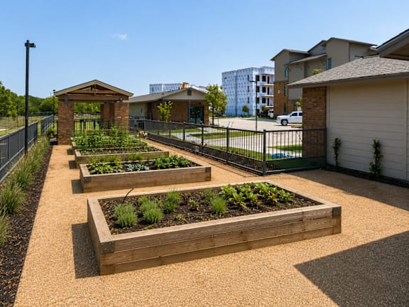 A community garden with raised beds and a small pavilion-like structure.