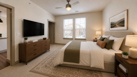 Spacious primary bedroom with large windows, ceiling fan, and designer finishes.