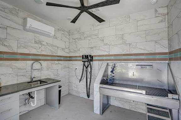 A bathroom with a marble tile wall and a tile floor.