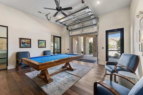 A room with a pool table and a chair.