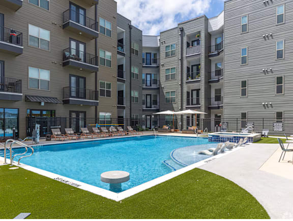 A swimming pool in front of apartment buildings.