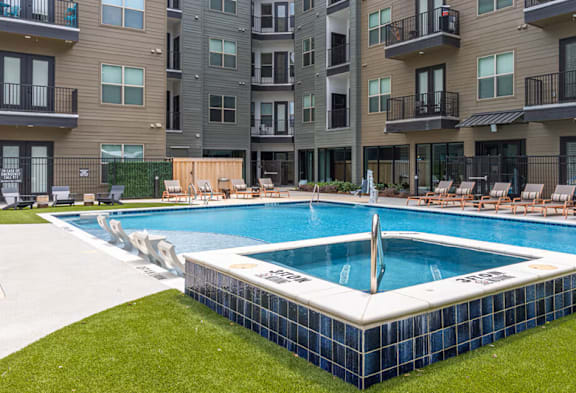 A swimming pool in front of apartment buildings.