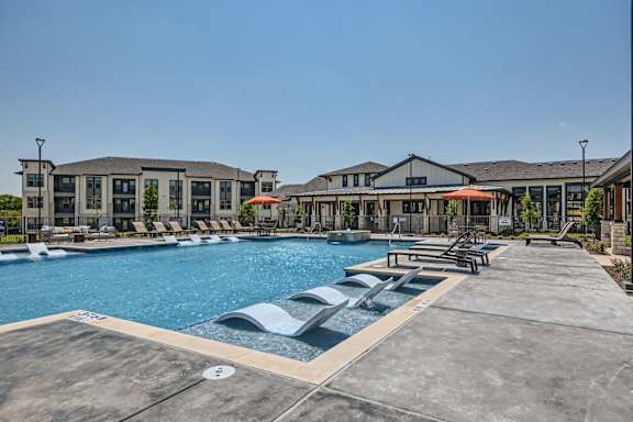 Resort-style swimming pool with tanning ledges at The Westerly Apartments in Midlothian Texas
