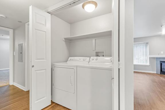 a white laundry room with a washer and dryer  at The Buttes Apartments Loveland, CO