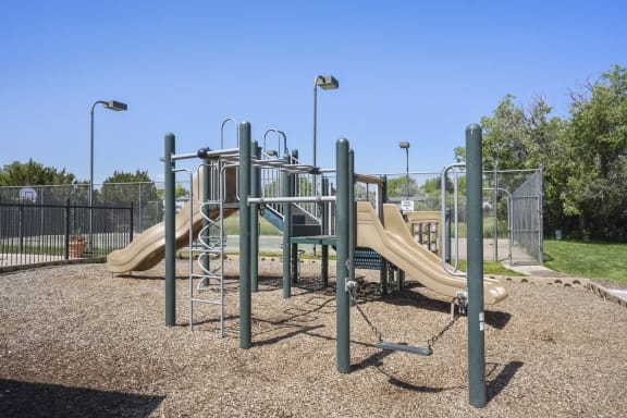 a playground with two slides and a climbing structure at Horizon East Apartments in Aurora, CO