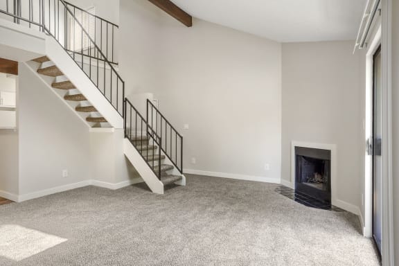 a living room with a staircase and a fireplace  at Hilltop View in Denver, CO