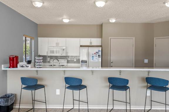 Clubhouse kitchen area with barstools and drink selection at Horizon East In Aurora.