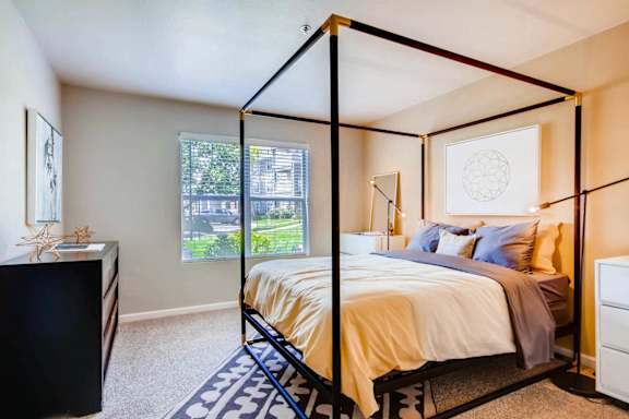 a bedroom with a canopy bed and a window