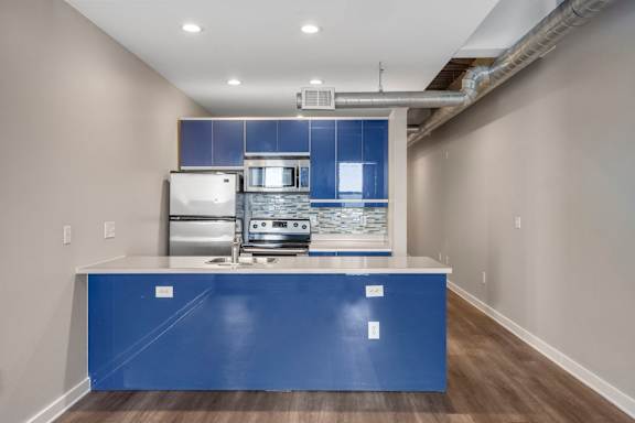 a kitchen with a blue counter top and a stove and refrigerator at Sleek Lofts Denver Colorado