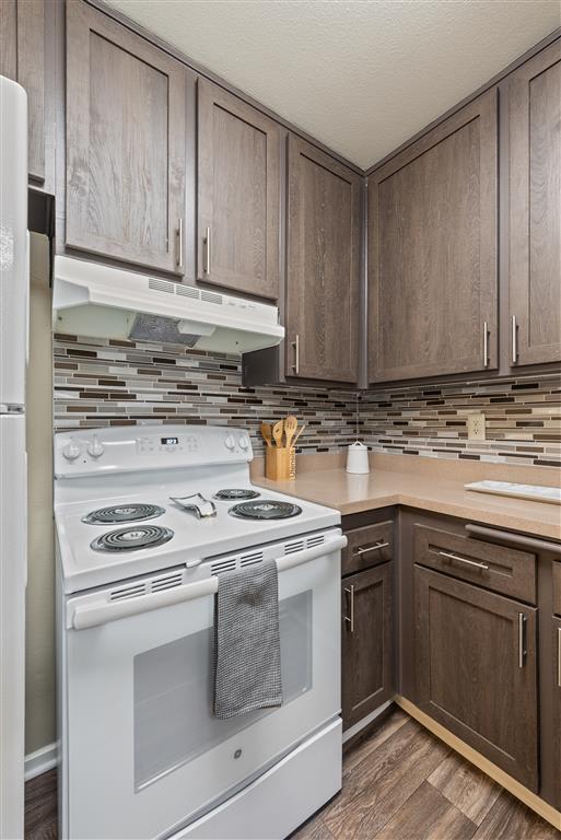 Renovated Kitchens featuring espresso cabinets, new electric range and elegant kitchen backsplashes at Chatsworth Pointe Apartments