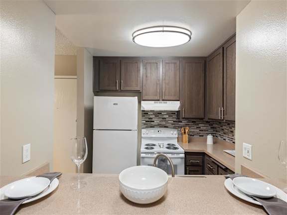 Renovated Kitchens featuring espresso cabinets, new electric range and elegant kitchen backsplashes at Chatsworth Pointe Apartments