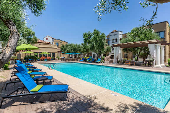 a swimming pool with blue and yellow lounge chairs at Trevi Apartment Homes, Chandler, AZ, 85224
